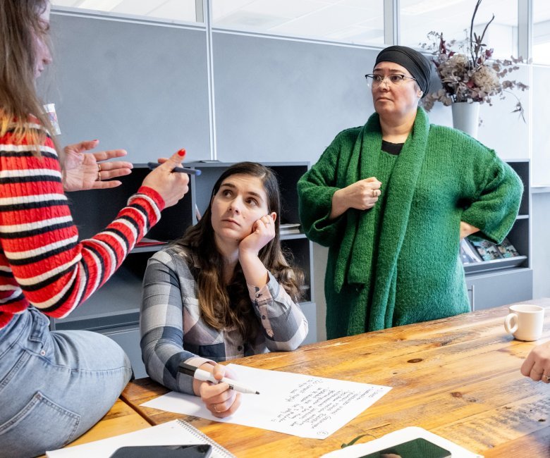 Drie professionals overleggen met elkaar