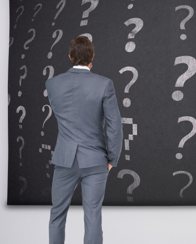 Man voor een blackboard vol vraagtekens