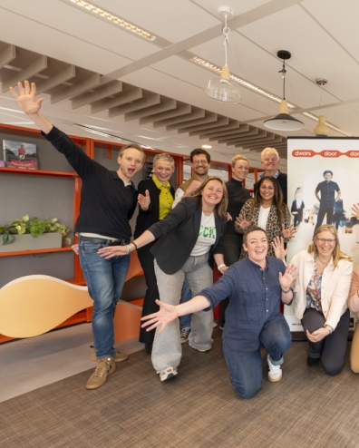 Deelnemers aan de kick-off zwaaien enthousiast voor de banner van Dwars door domeinen