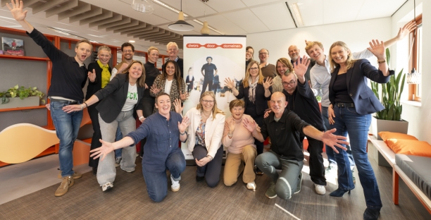 Deelnemers aan de kick-off zwaaien enthousiast voor de banner van Dwars door domeinen