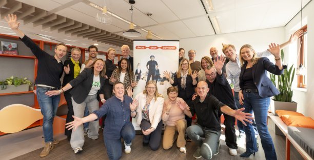 Deelnemers aan de kick-off zwaaien enthousiast voor de banner van Dwars door domeinen