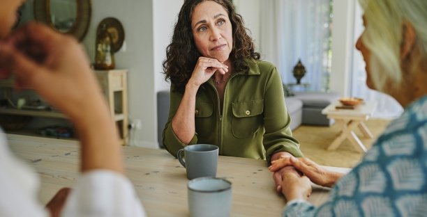 Drie mensen serieus in gesprek aan een tafel