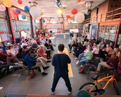 Rico Bakker op de rug gezien, met daarachter een zaal met deelnemers