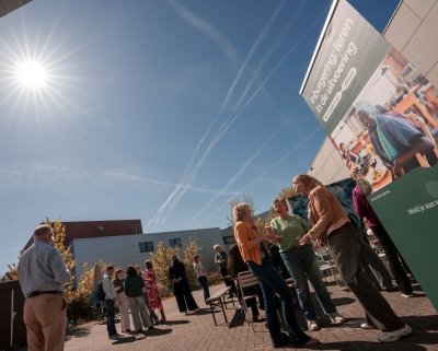 Deelnemers borrelen staand in de buitenlucht