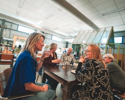 Deelnemers in gesprek met elkaar, zittend aan een tafel