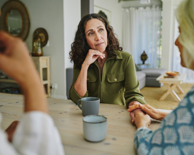 Drie mensen serieus in gesprek aan een tafel
