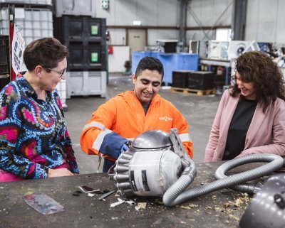 Mohamad haalt apparaten uit elkaar voor recycling, Miriam en Woutine kijken toe