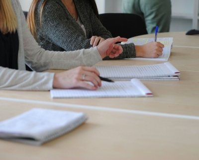 mensen aan tafel met notitieblokken
