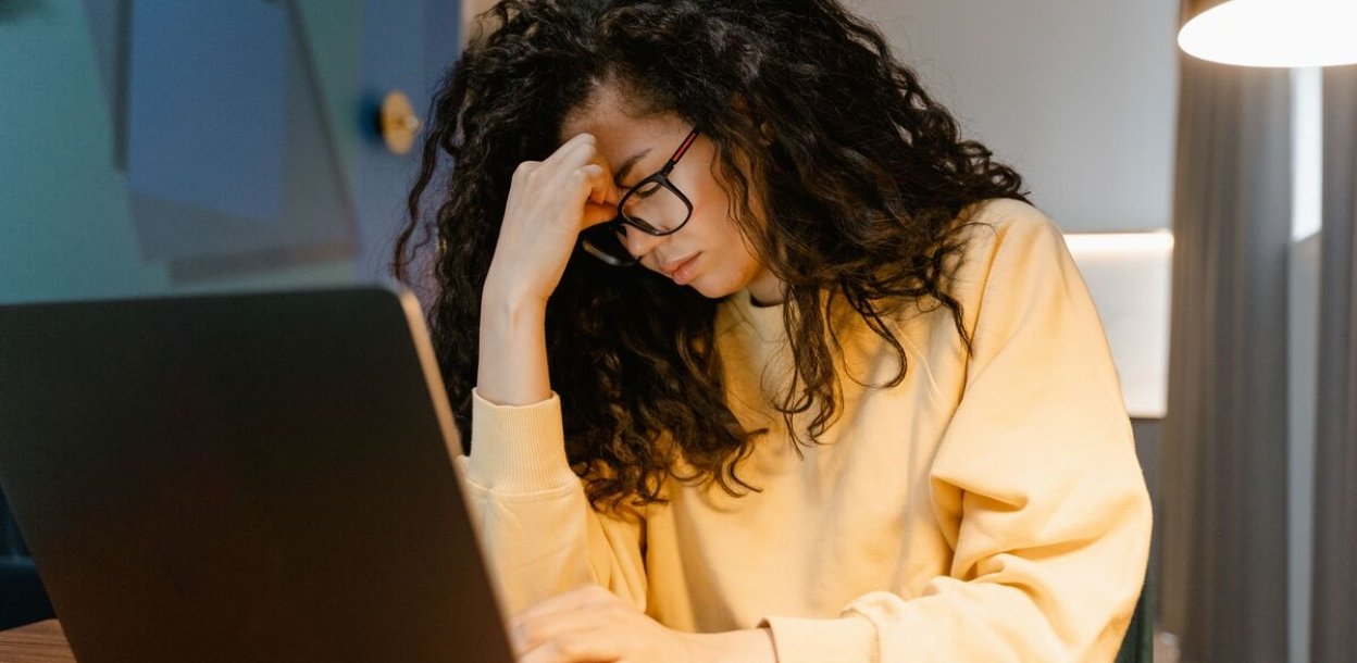 gestrest persoon achter laptop
