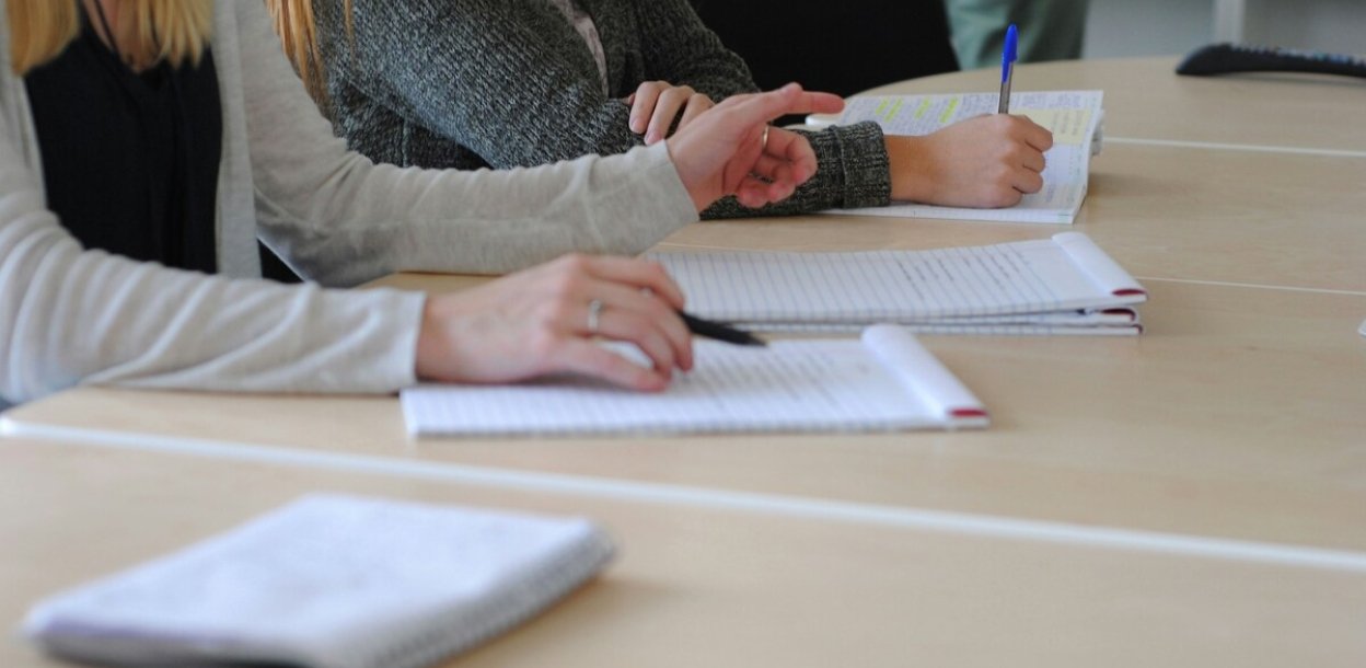 mensen aan tafel met notitieblokken