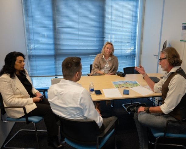 Staatssecretaris Coenradie in gesprek met een inburgeraar en een klantmanager inburgering